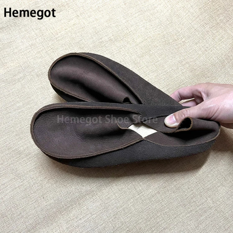 Dunkle Lederschlupf-Loafer mit weicher Sohle, Hand zeigt Einstieg