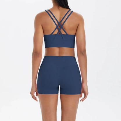 dunkelblaues Damen Yoga-Set von hinten: Sport-BH mit gekreuzten Trägern und kurze Shorts