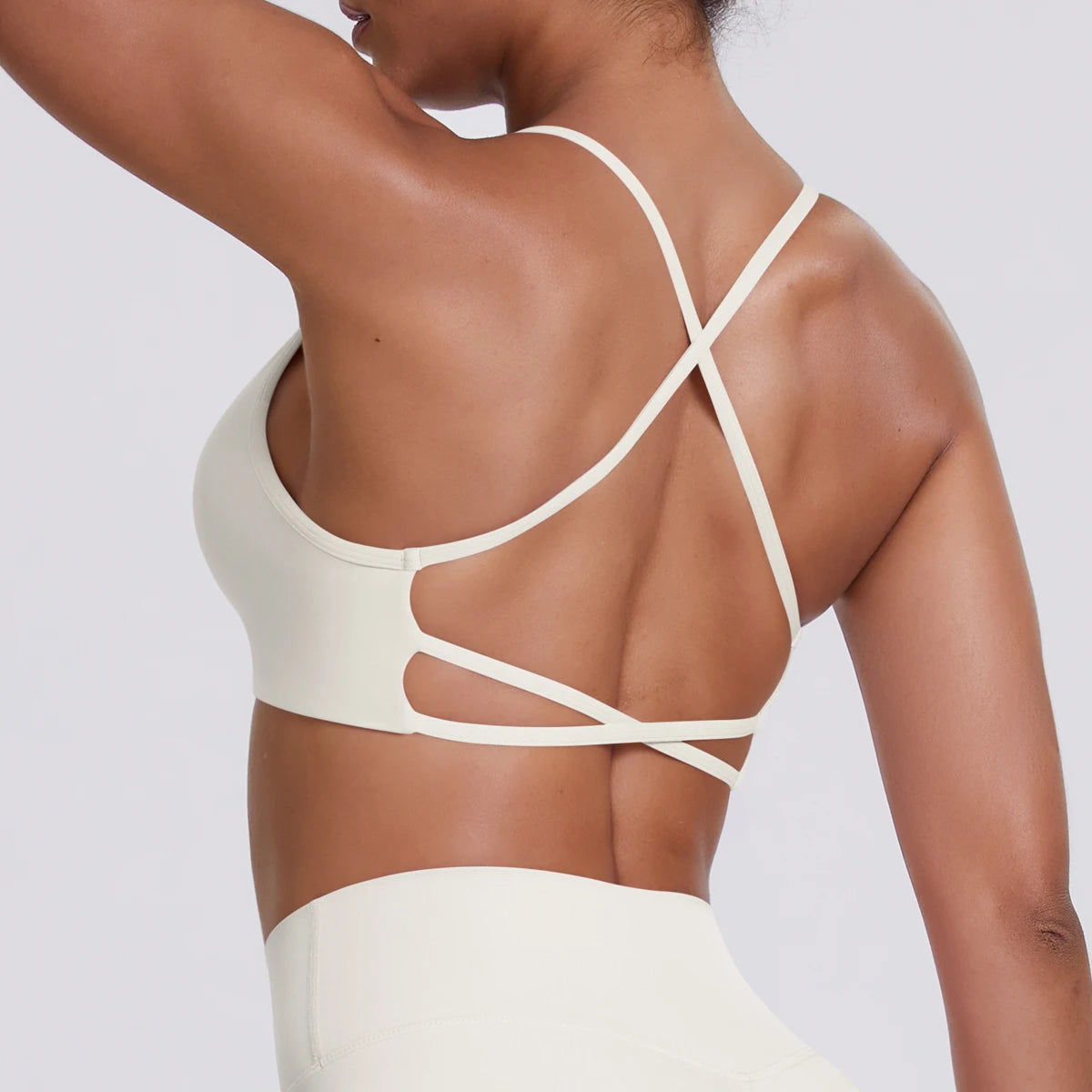 Hellivoryfarbenes Sport-Crop-Top, Rückansicht mit gekreuzten Trägern und Einschnitten