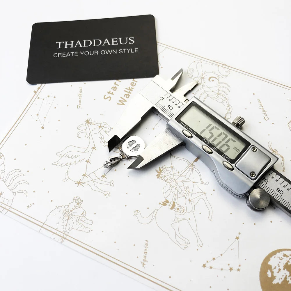 Baby-Fußabdruck-Anhänger aus 925-Sterlingsilber auf Schmuckkarte, neben Messgerät