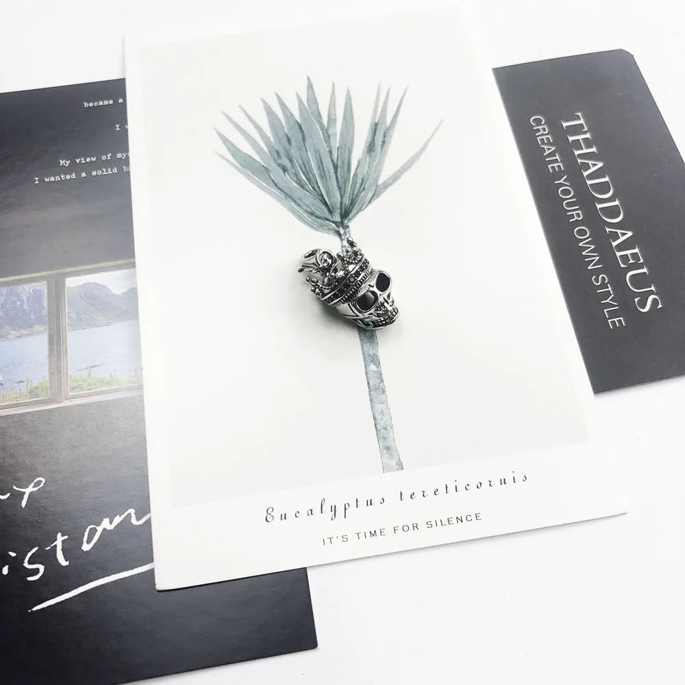 Silberner Totenkopf-König Anhänger mit Kettenöse, auf Postkarte