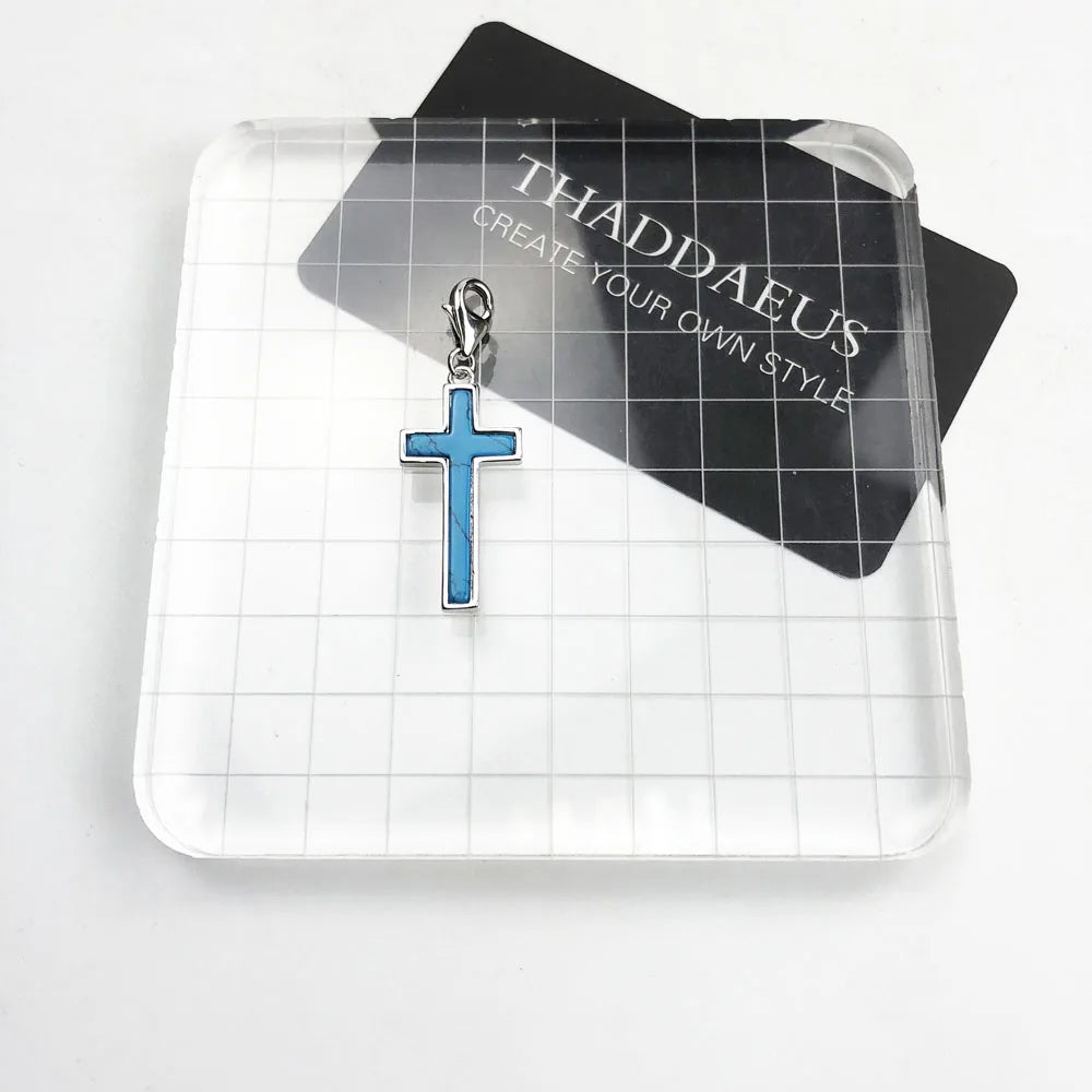 Kreuz-Charm-Anhänger aus Sterlingsilber mit blauem Kreuz auf Schmuckkarte