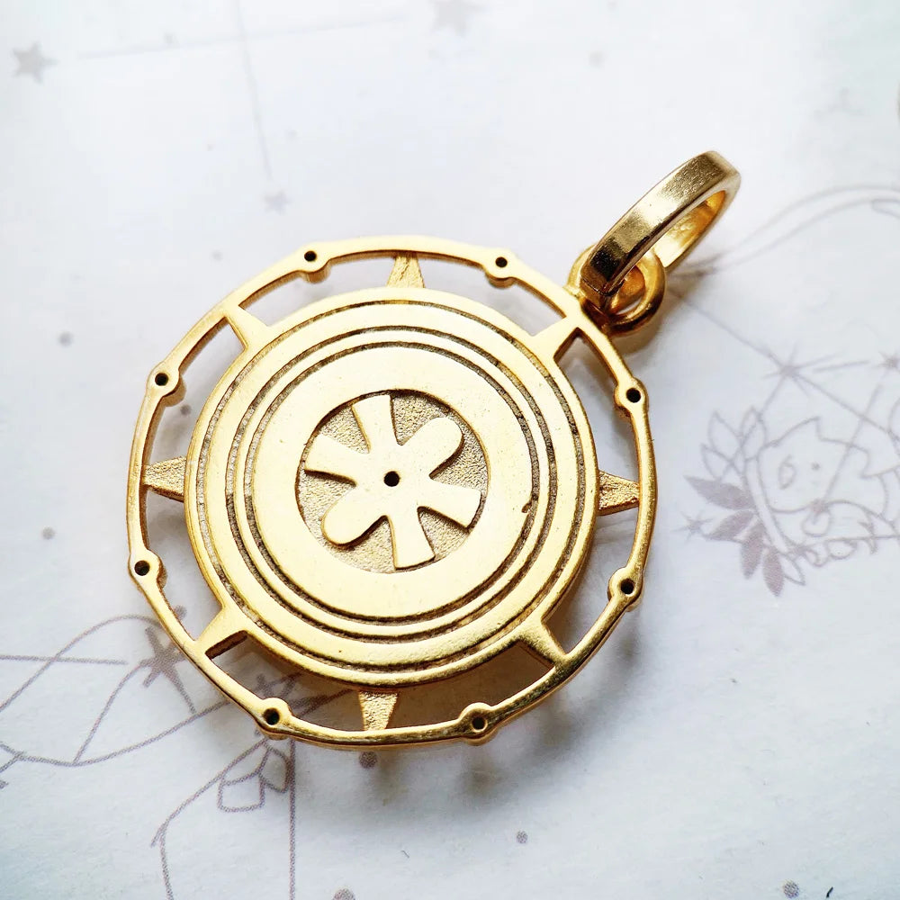 Goldfarbener Anhänger mit kreisförmiger Prägung und vierblättrigem Symbol