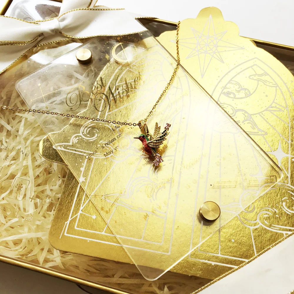 Kolibri-Halskette mit goldfarbener Kette und farbigem Vogelanhänger auf Accessoires