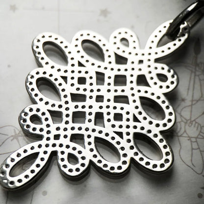 Anhänger Love-Knoten als filigranes Blumen-Ornament, viele Glitzerpunkte im Muster