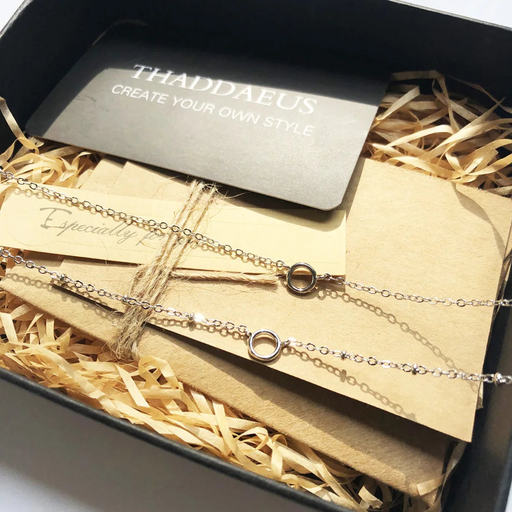 Doppelte Silberhalskette mit zwei Ring-Charms in Geschenkbox mit Etikett