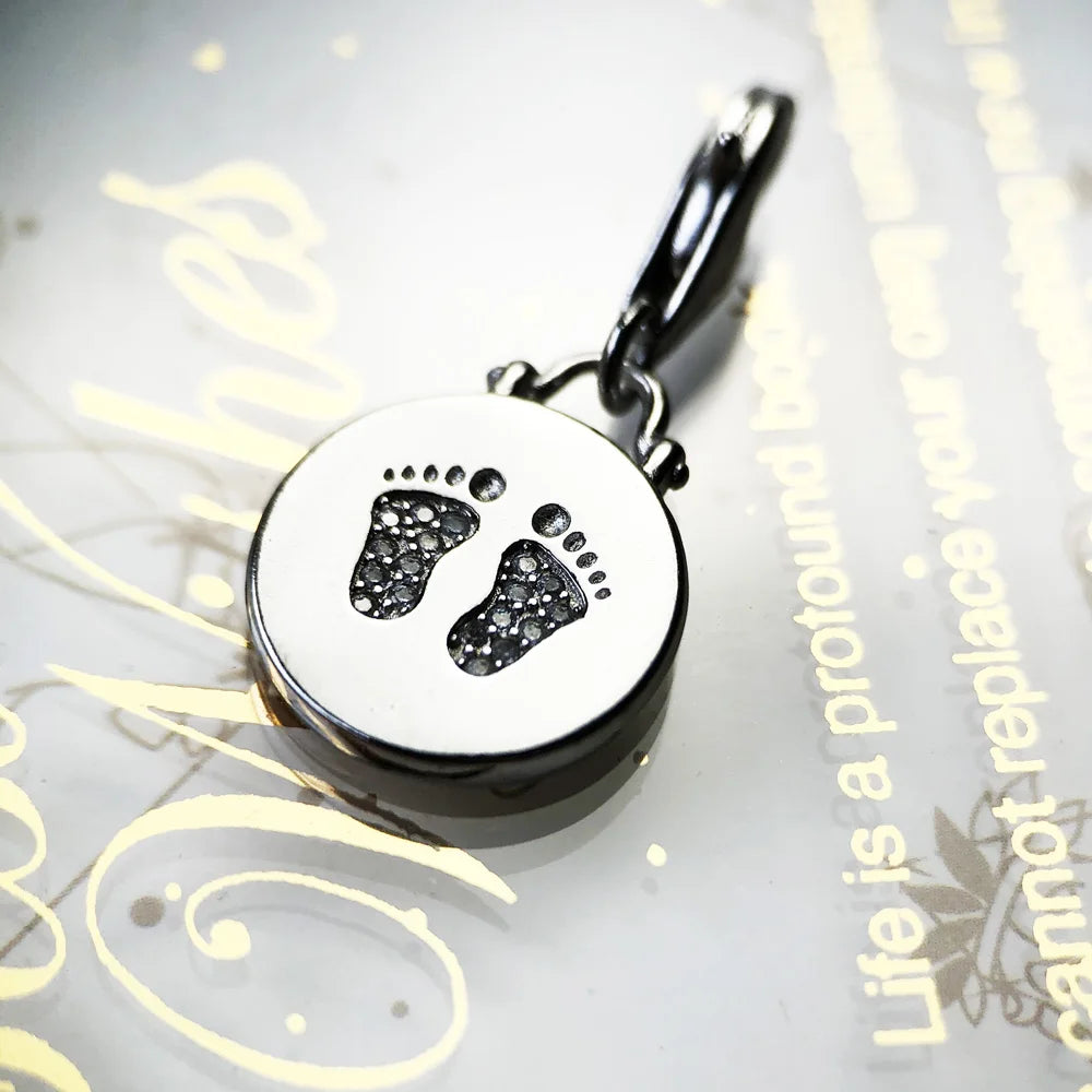 Runder Anhänger-Disc aus 925 Sterling Silber mit Baby-Fußabdruck-Motiv und Öse.