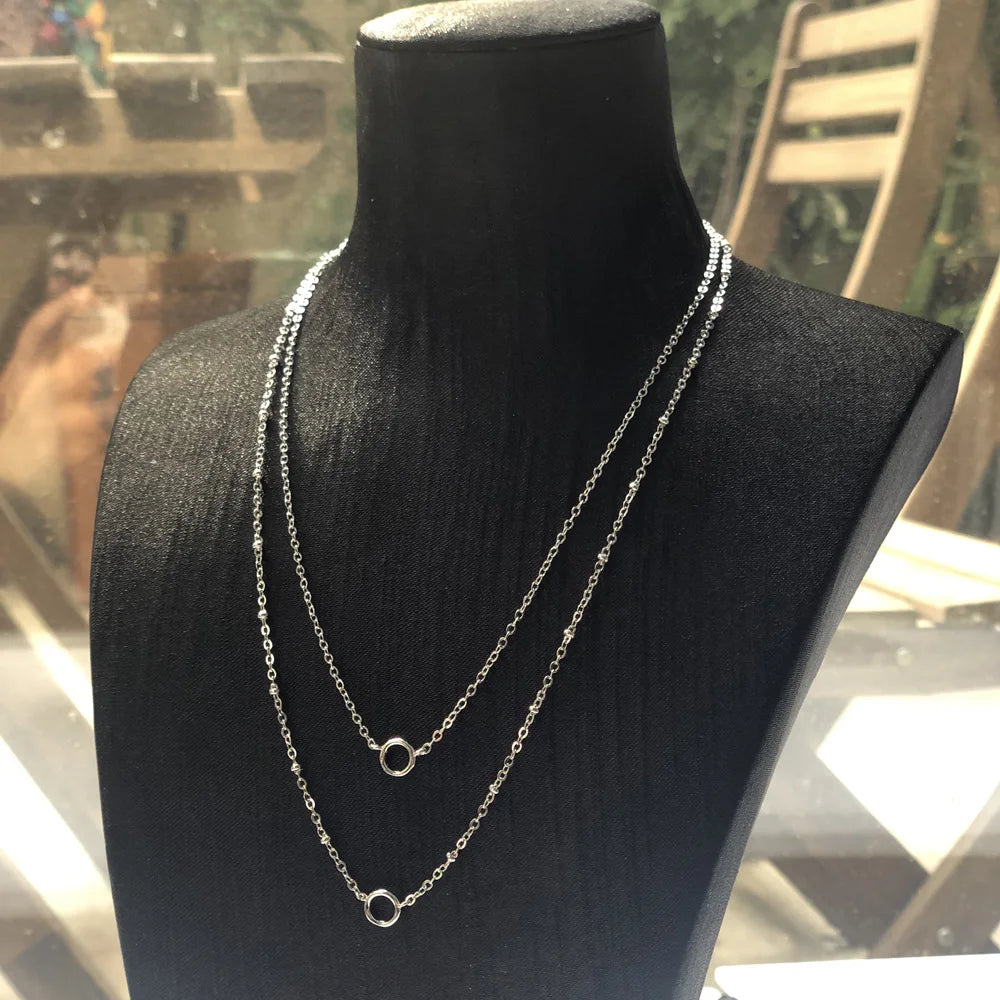 Doppelte 925-Silberhalskette mit zwei runden Ring-Charms am Schmuckständer