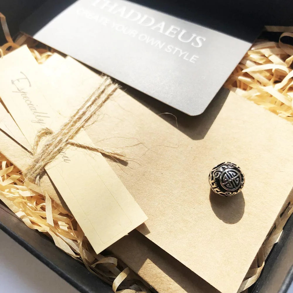 Silberner runder Charm in Geschenkverpackung, Ethno-Ornament mit dunkler Füllung