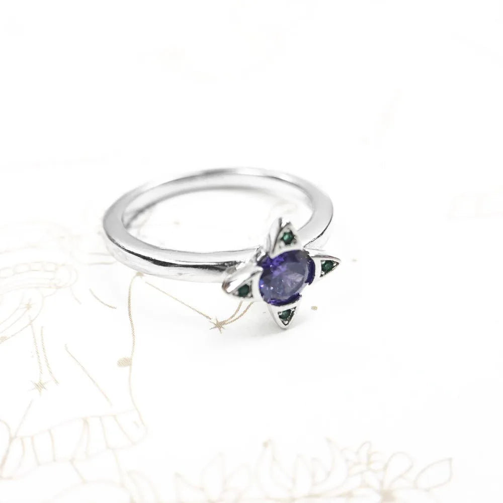 Ring auf hellem Untergrund: 925 Silber mit violettem Stein und grünen Akzenten