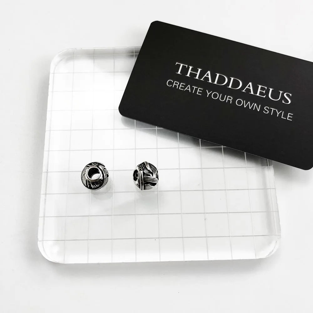 Silberne Charm-Perle mit schwarzem Federrelief, im Marken-Set mit zwei Charms