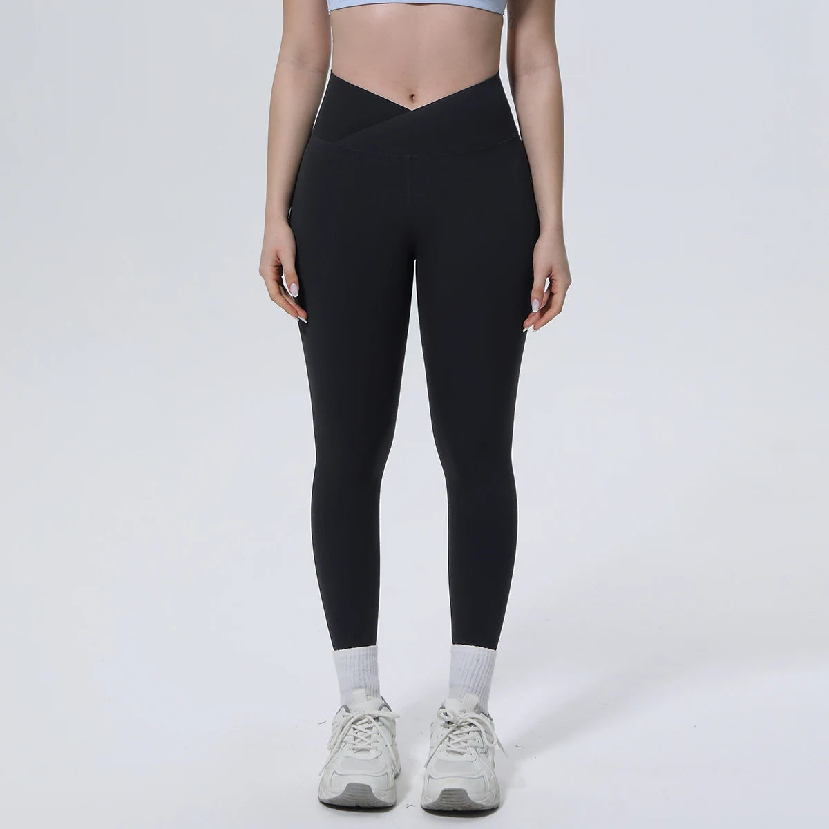 Schwarze Yoga-Leggings mit Cross-Waist-Bund, figurbetontem Bein bis zum Knöchel