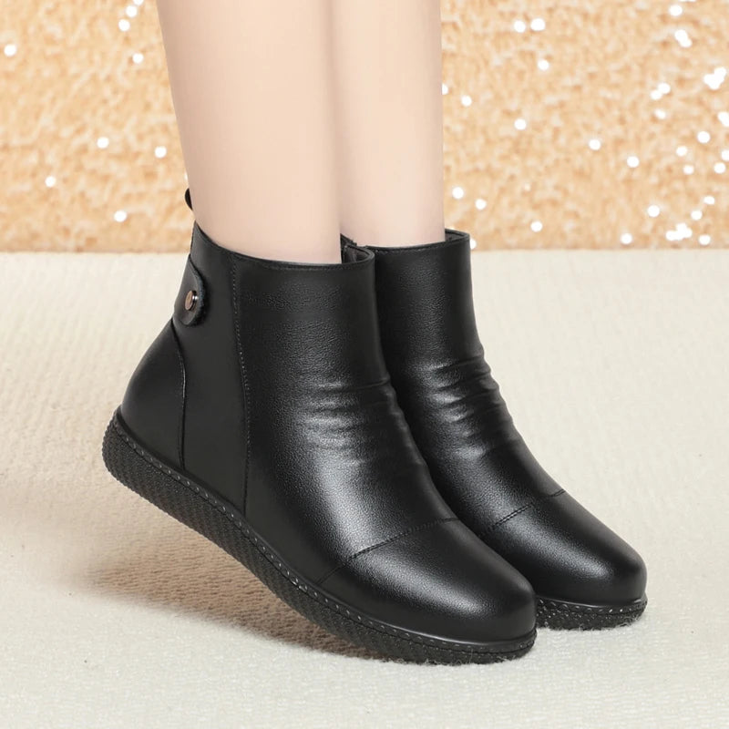 Paar schwarze Kurzstiefel mit flachem Sohlenprofil und Knopf-Detail am Schaft