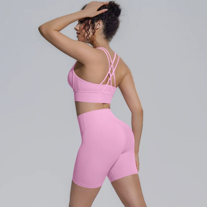 Rosa Yoga-Set von hinten: Sporttop mit gekreuzten Trägern über Shorts