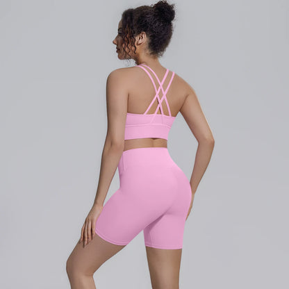 Rosa Yoga-Set von hinten: gekreuzte Träger am Sporttop über Shorts