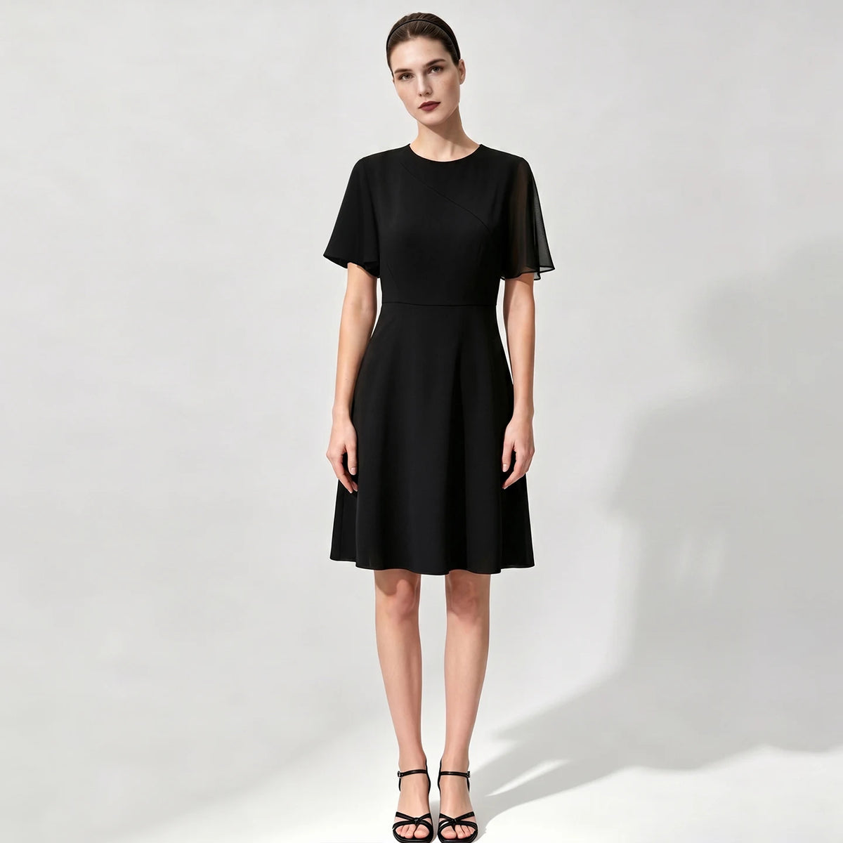 Schwarzes tailliertes Damenkleid mit kurzen Ärmeln und A-Linien-Rock, knielang
