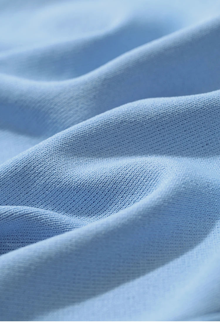 Nahaufnahme Strickstoff: hellblauer, feiner Strick mit sichtbarer Maschenstruktur