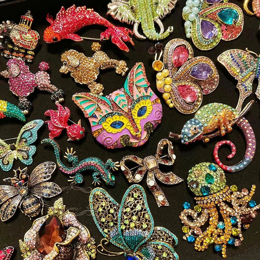 Kristall- und Strass-Broschen mit Tiermotiven, buntes Set auf dunklem Untergrund