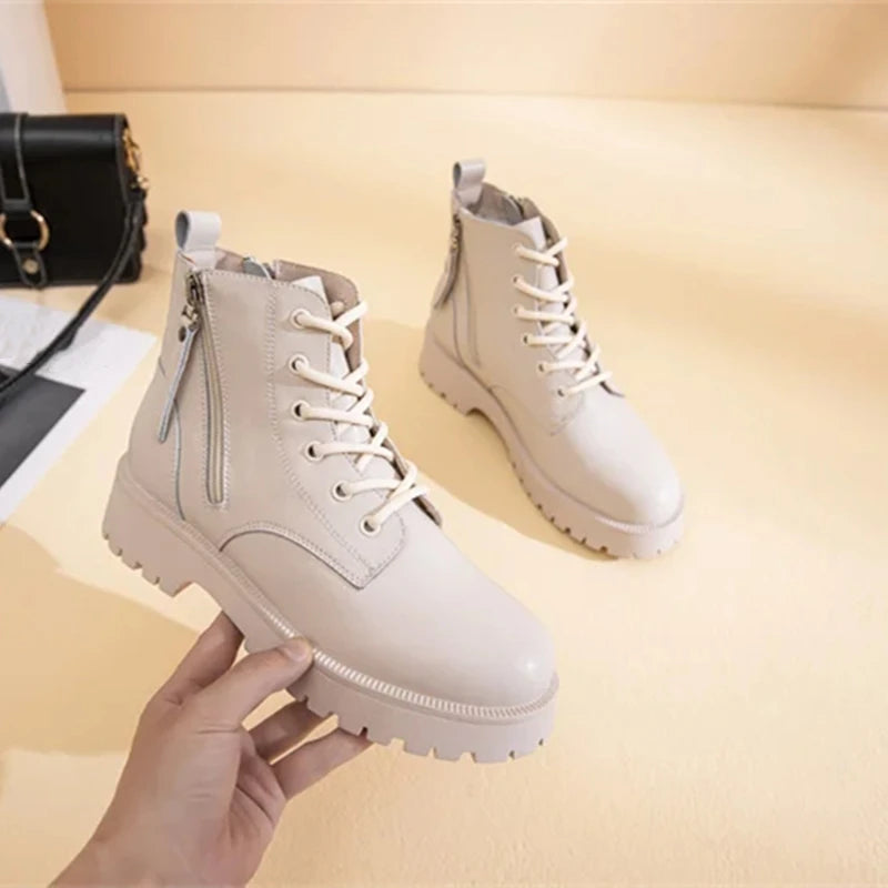 Beige Stiefeletten mit Kunstfell, Schnürung und zwei Reißverschlüssen, robuste Profilsohle.