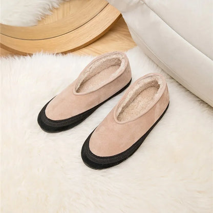 Flache Schneestiefel in Beige mit schwarzem Rand, paarweise auf hellem Fell