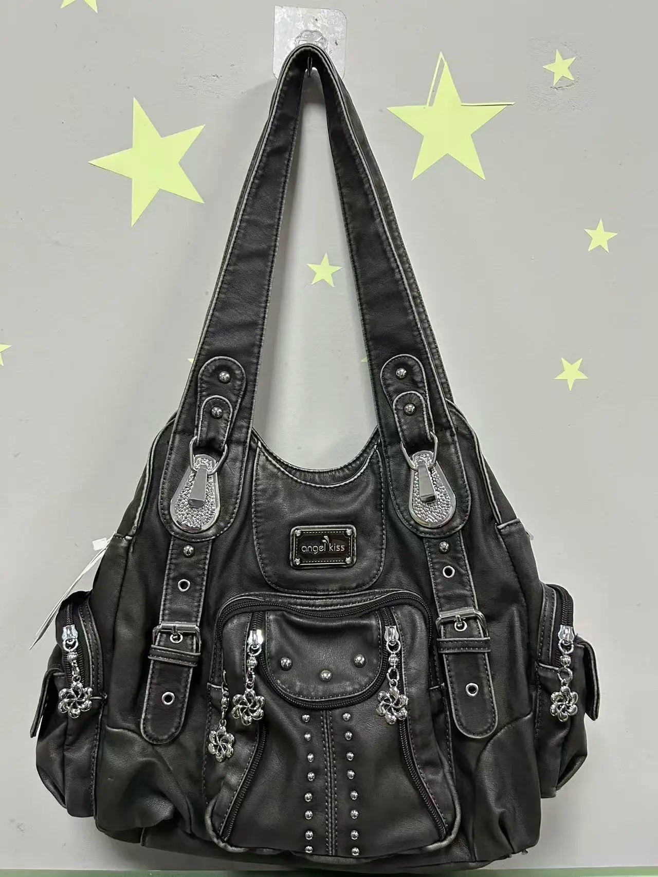 Schwarze Damen-Schultertasche aus PU mit Ziernieten, Steckfächern und Schmuckanhängern.