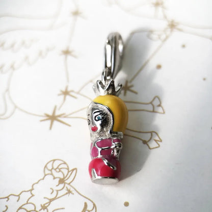 Charm-Anhänger mit Puppenkopf, gelbem Haar, pinkem Kleid in silberner Fassung