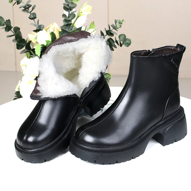 Schwarze Ankle-Boots mit weißem Fellfutter, glatter Oberfläche und robuster Profilsohle