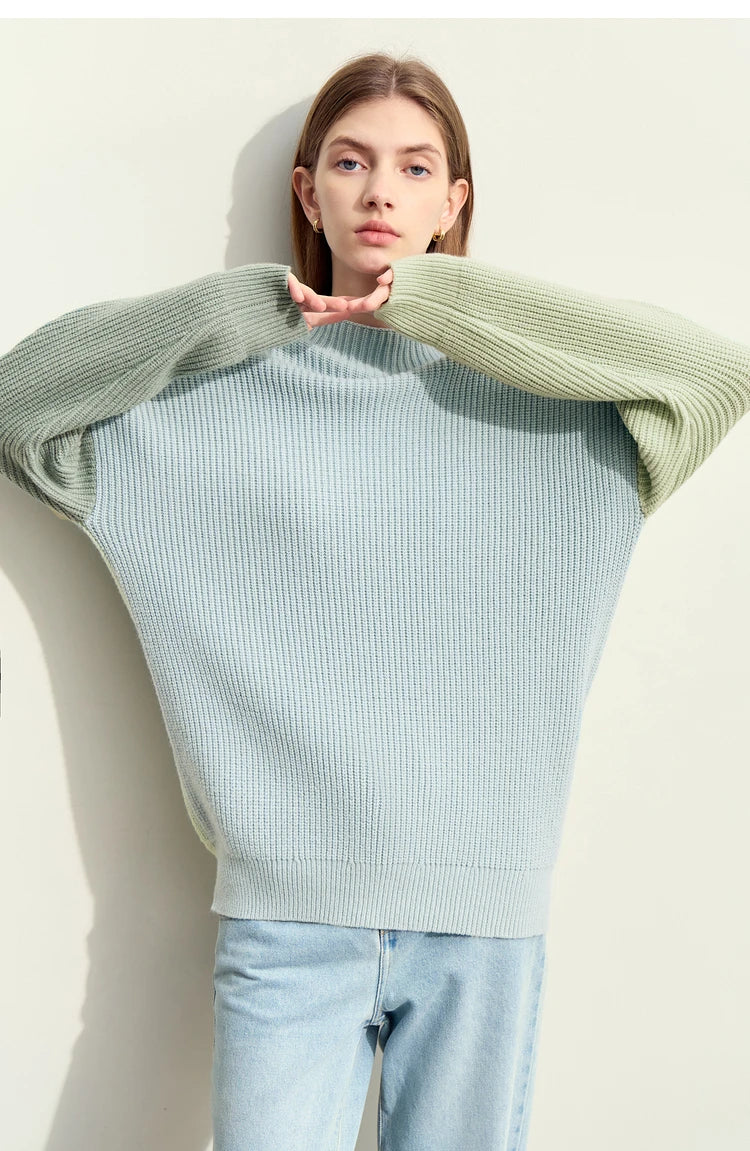 Rollkragenstrickpullover im Rippenmuster, hellblau mit grünen Ärmeln und entspannter Passform.