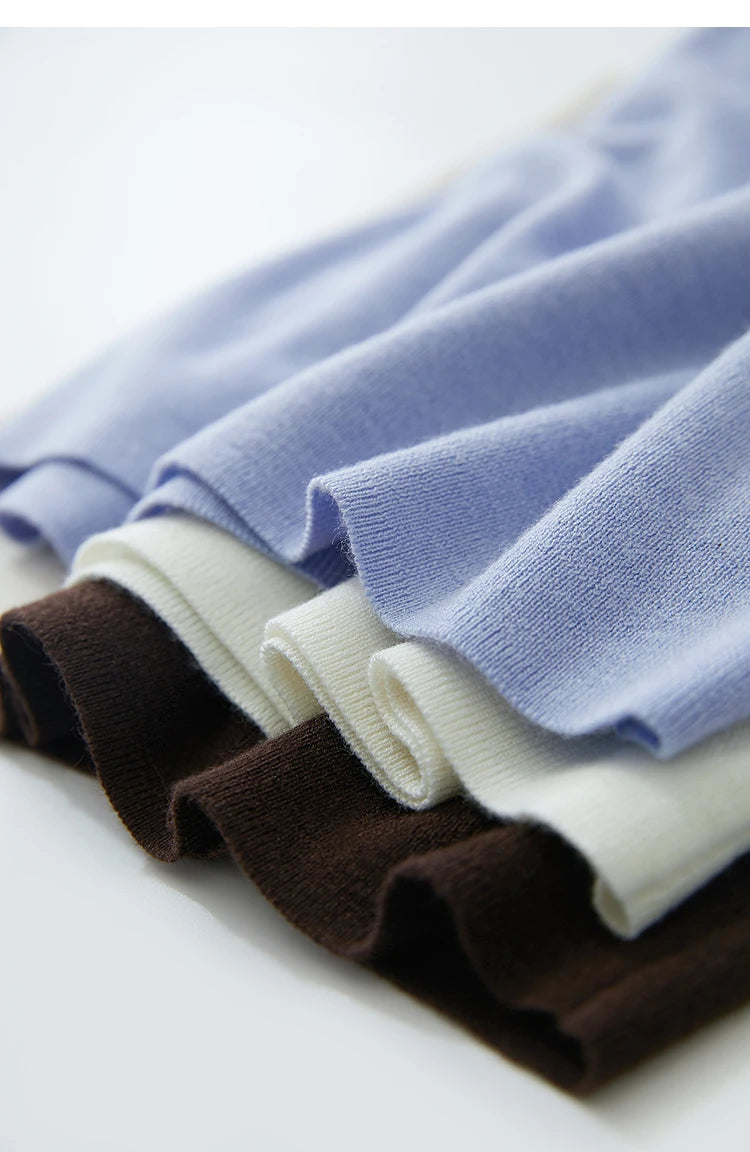 Gefaltete Strickoberteile in Himmelblau, Creme und Dunkelbraun mit feiner Rippstruktur