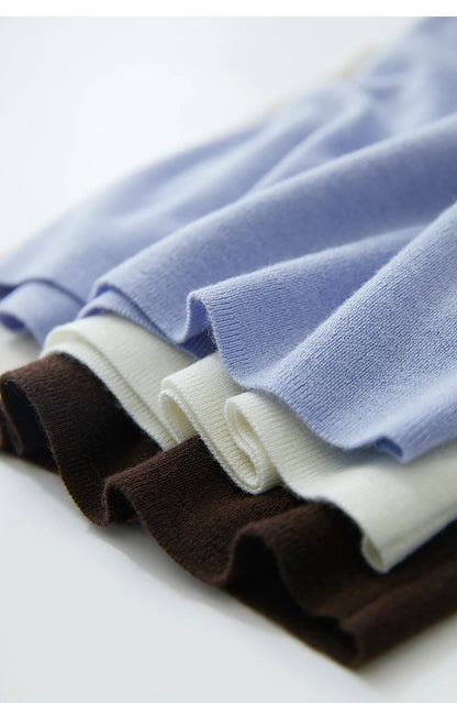 Gefaltete Strickoberteile in Himmelblau, Creme und Dunkelbraun mit feiner Rippstruktur