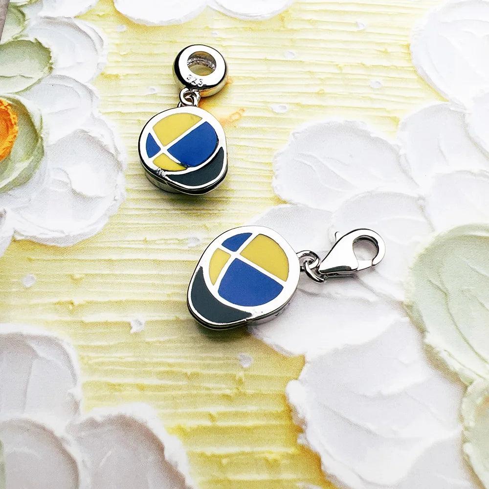 Silberner Dangle-Charm mit rundem Motiv: blau-gelbes Detail im schwarzen Rahmen