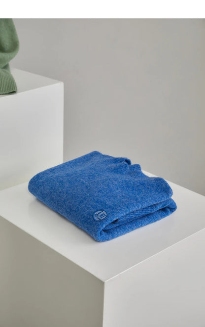 Zusammengelegter blauer Pullover mit besticktem Logo, weicher Strickstoff