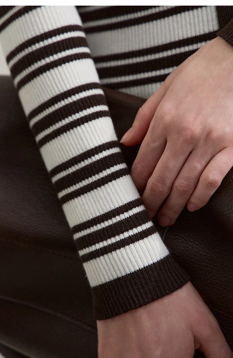 Detail am Strickärmel: schwarz-weiße Streifen und geripptes Bündchen