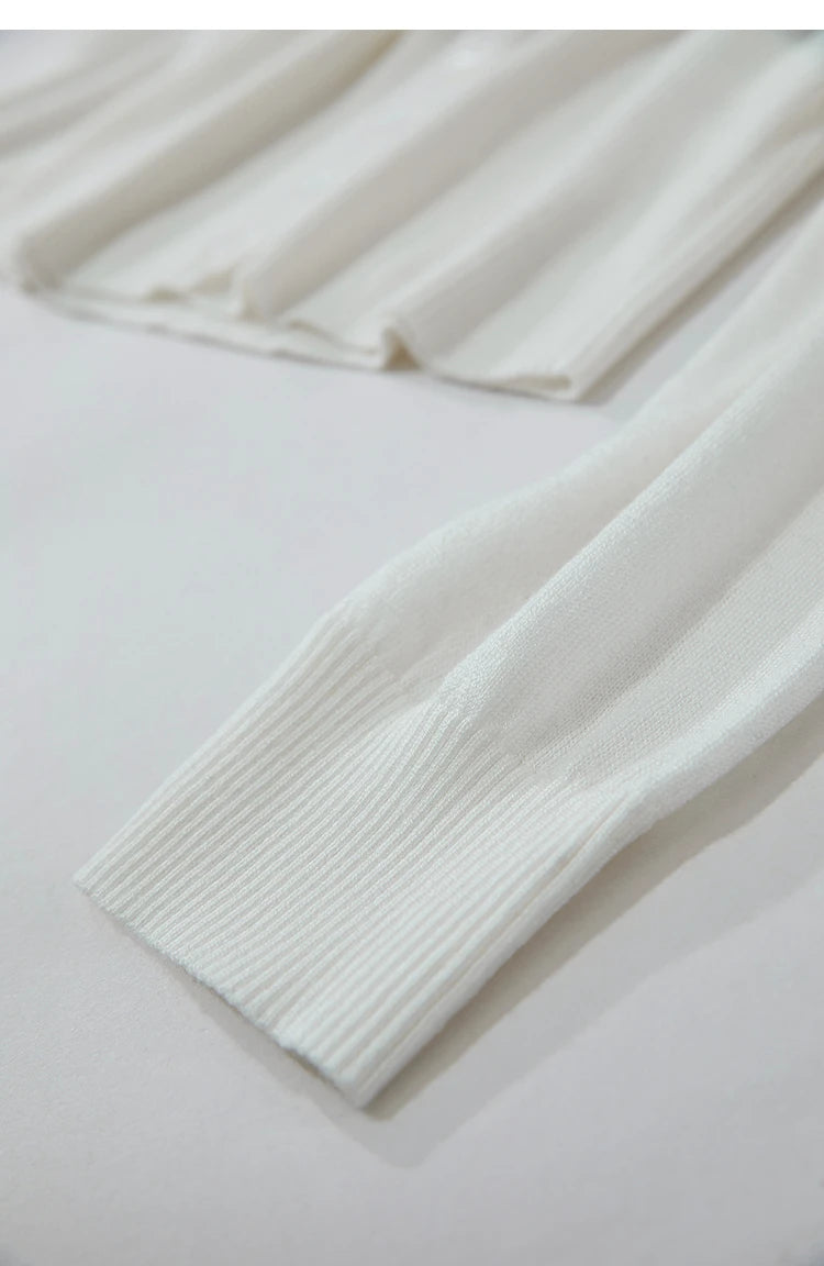 Nahaufnahme Ärmelbund: Weißer Damenpullover mit geripptem Abschluss und feinem Strickmuster