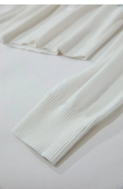 Nahaufnahme Ärmelbund: Weißer Damenpullover mit geripptem Abschluss und feinem Strickmuster