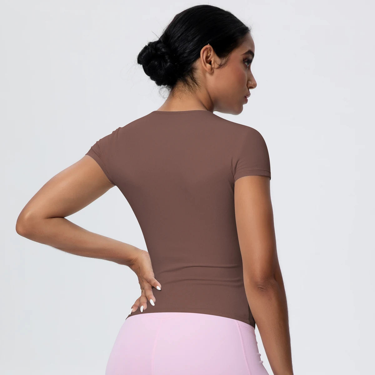 Nike Yoga-Top mit Kurzarm und Rundhalsausschnitt, Rückansicht schräg, braun