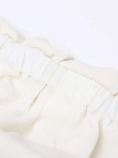 Elegantes Damen-Kleid mit Rundhalsausschnitt, kurzen Ärmeln und unregelmäßigem Patchwork-Design – figurbetont und stilvoll.