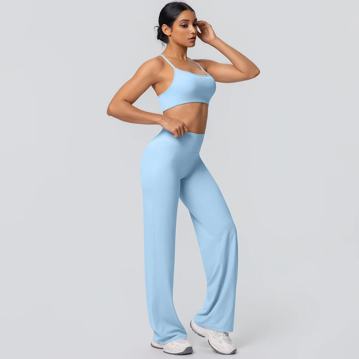 Sport-BH und weite Yoga-Hose in hellblau, frontseitig, entspannte Pose