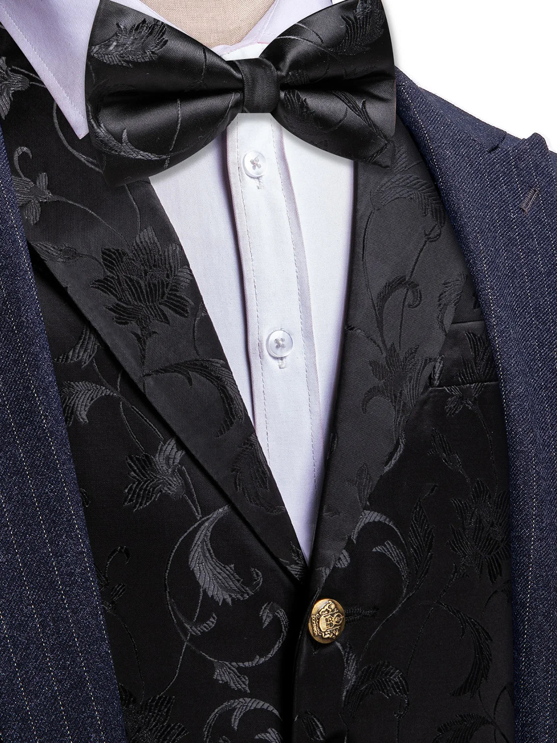 Schwarze Herrenweste mit dunklem Ornamentmuster, schwarze Fliege und goldfarbener Knopf