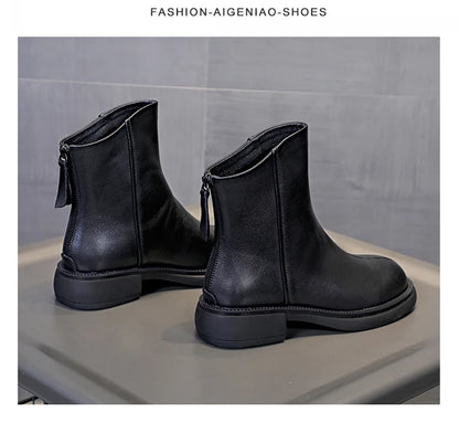 Schwarze Leder-Stiefeletten mit Ziernaht am Schaft und flacher Profilsohle, schräg von der Seite.