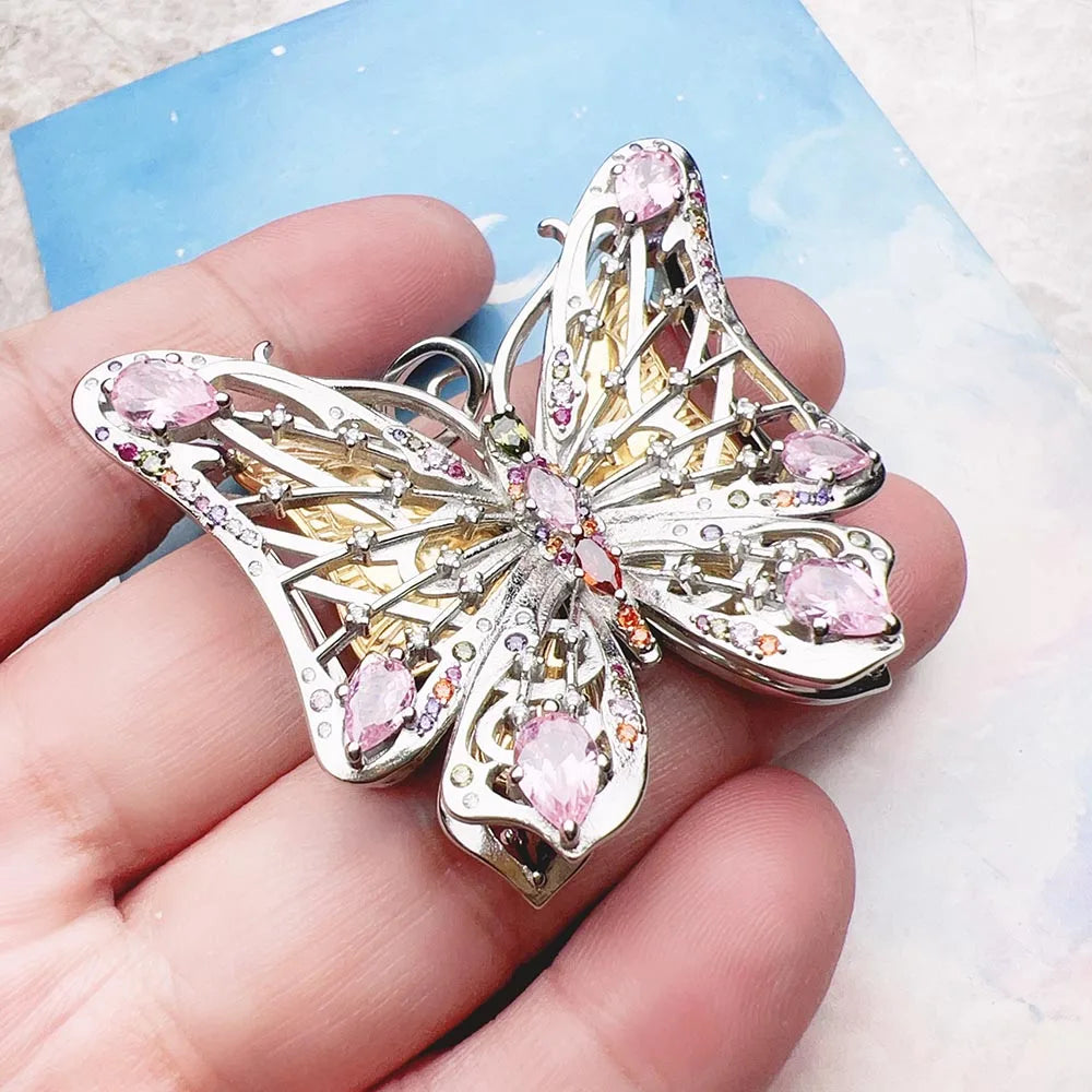 Schmuckanhänger Schmetterling aus Sterlingsilber in Hand gehalten, rosa Steine, Detailansicht