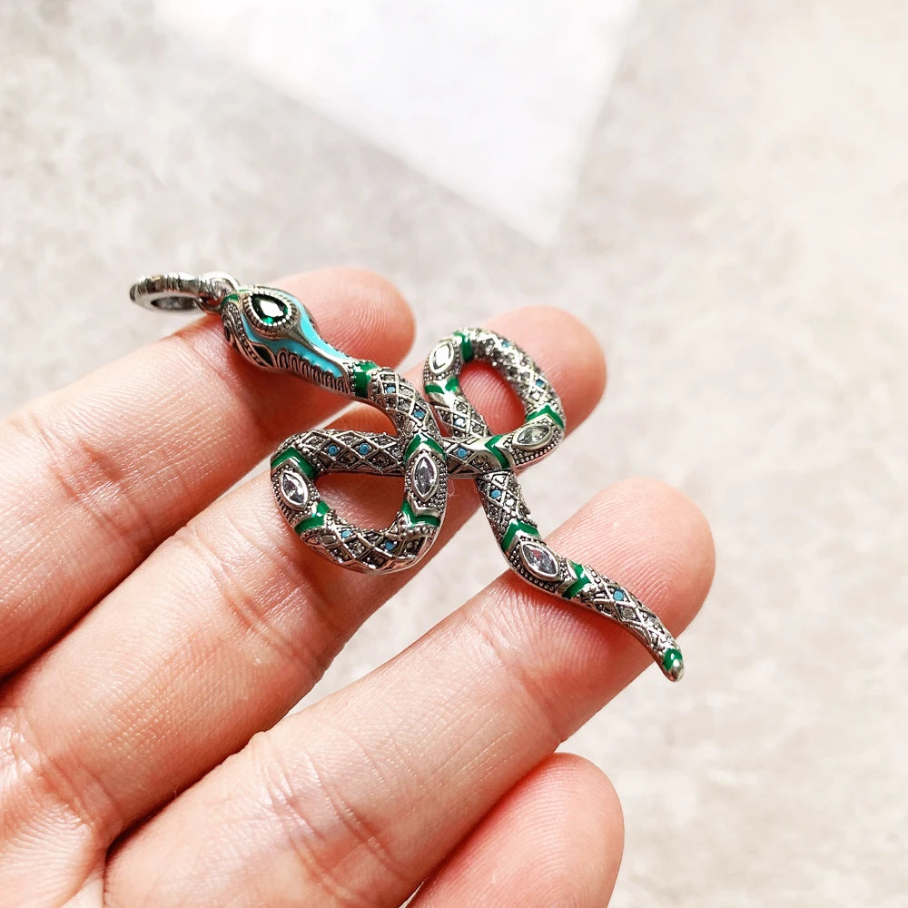 Kleiner Schlangen-Anhänger in Sterlingsilber mit grünen Akzenten, in der Hand
