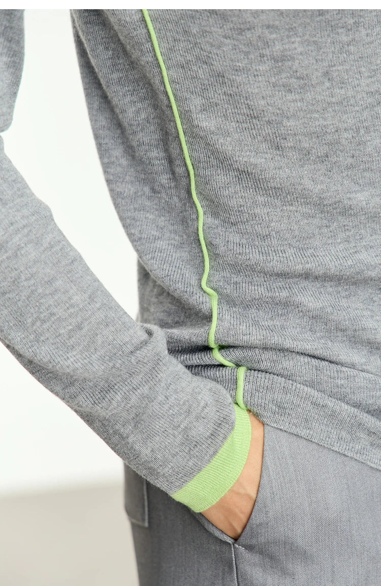 Damenpullover Nahaufnahme: grauer Strick mit grüner Paspel an Ärmelbündchen
