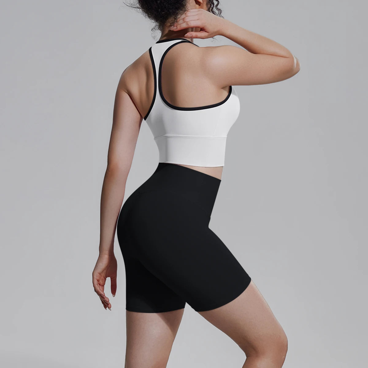 Yoga-Set für Damen von hinten: Träger-Top mit schwarzem Saum, schwarze Shorts