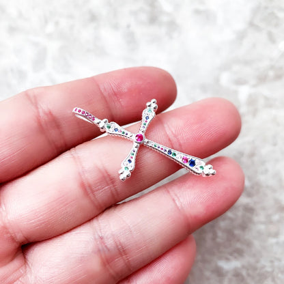 Kreuz-Anhänger aus Sterlingsilber mit bunten Zirkonia, in der Hand gehalten
