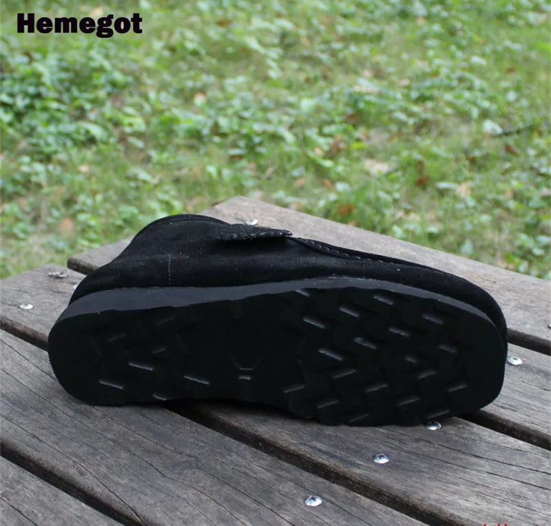 Schwarze Gummisohle eines Herren-Boots mit kräftigem Profil und Stollen