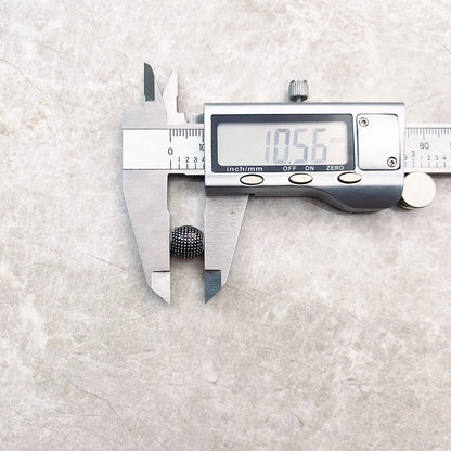 Kathmandu Charm-Perle aus 925er Sterlingsilber neben Messschieber, rundes Noppenrelief