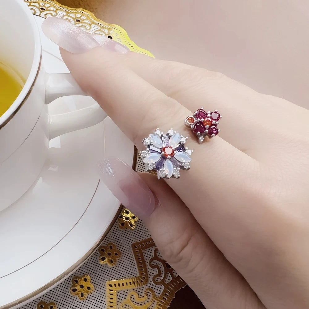Blumenring-Sets am Finger: rosa und lila Steinblüten, silberfarbene Ringschienen