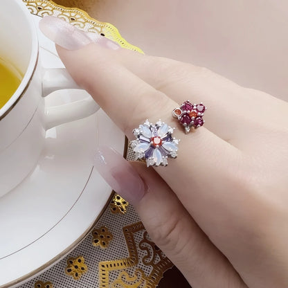 Blumenring-Sets am Finger: rosa und lila Steinblüten, silberfarbene Ringschienen