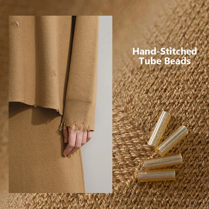 Nahaufnahme: handgestickte Röhrenperlen am Saum eines braunen Strickstoffs